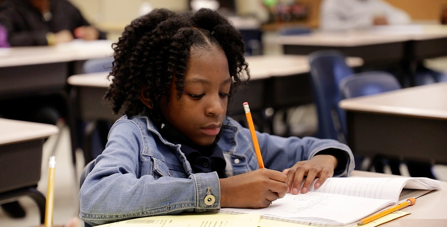 student writing in a notebook