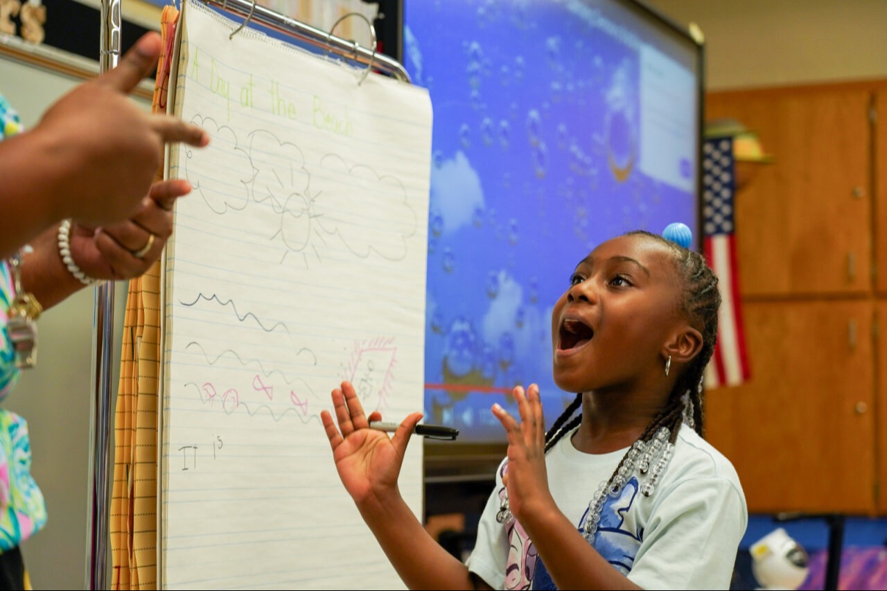 Student working on an assignment at the front of the class