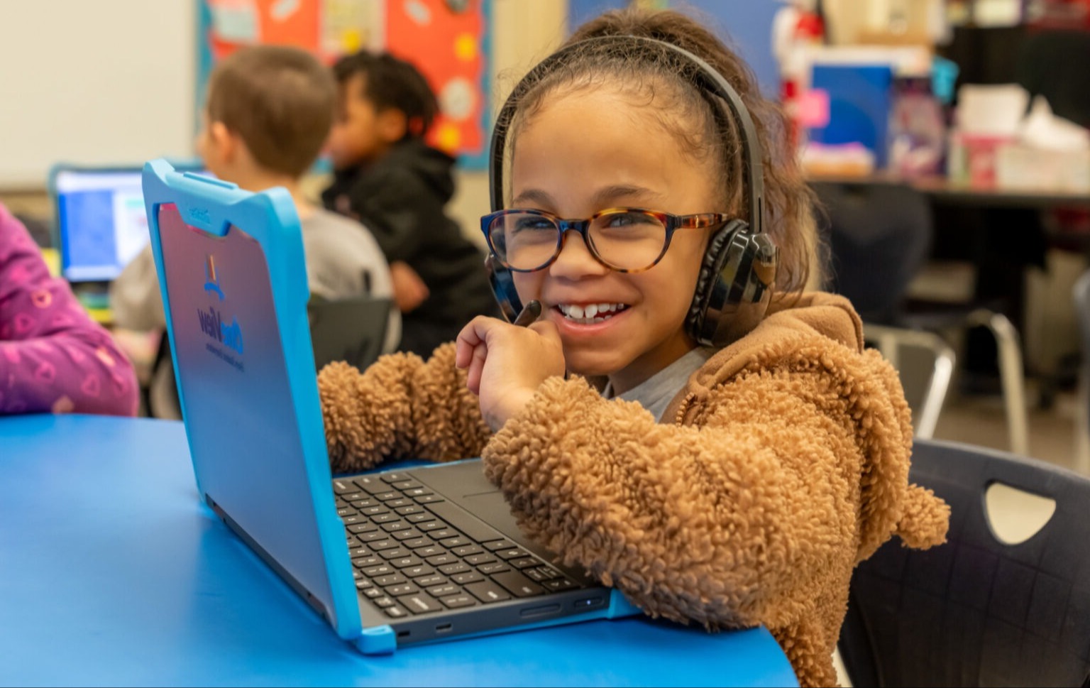 Student smiling while working on a laptop