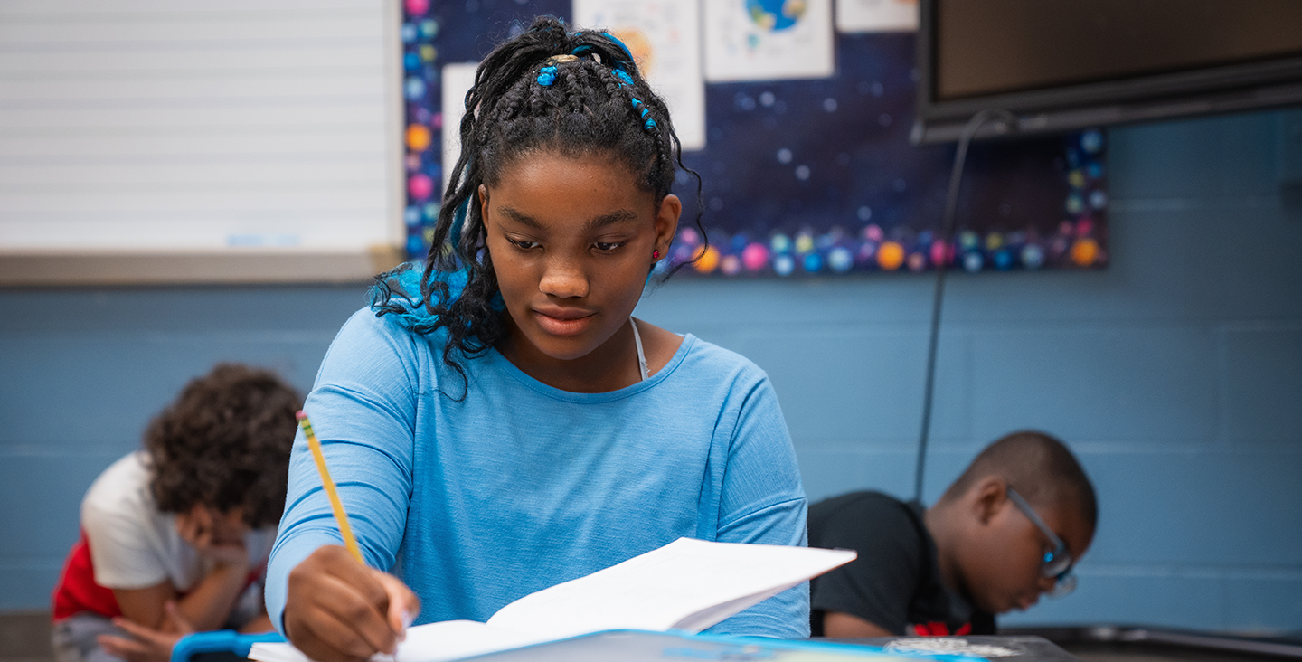 Girl in class writing in her notebook