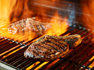 Steak on a grill with open flames