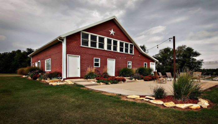 RED BARN WITH PLANTS IN YARD