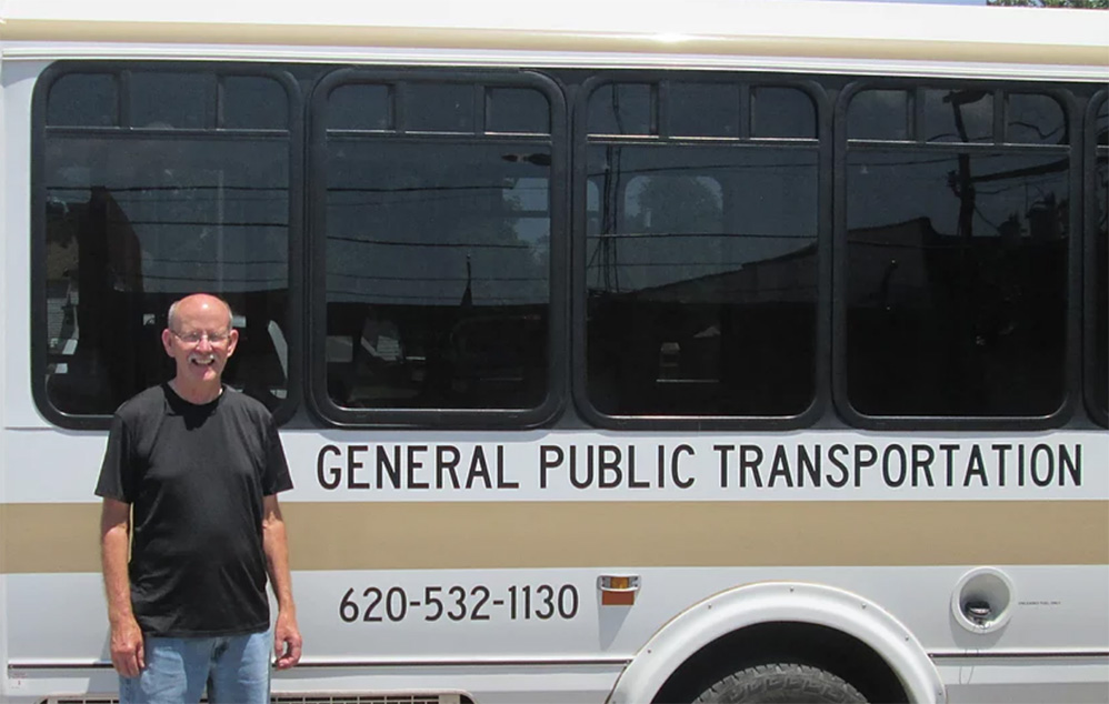 Driver Ken McGinnis standing next to bus 