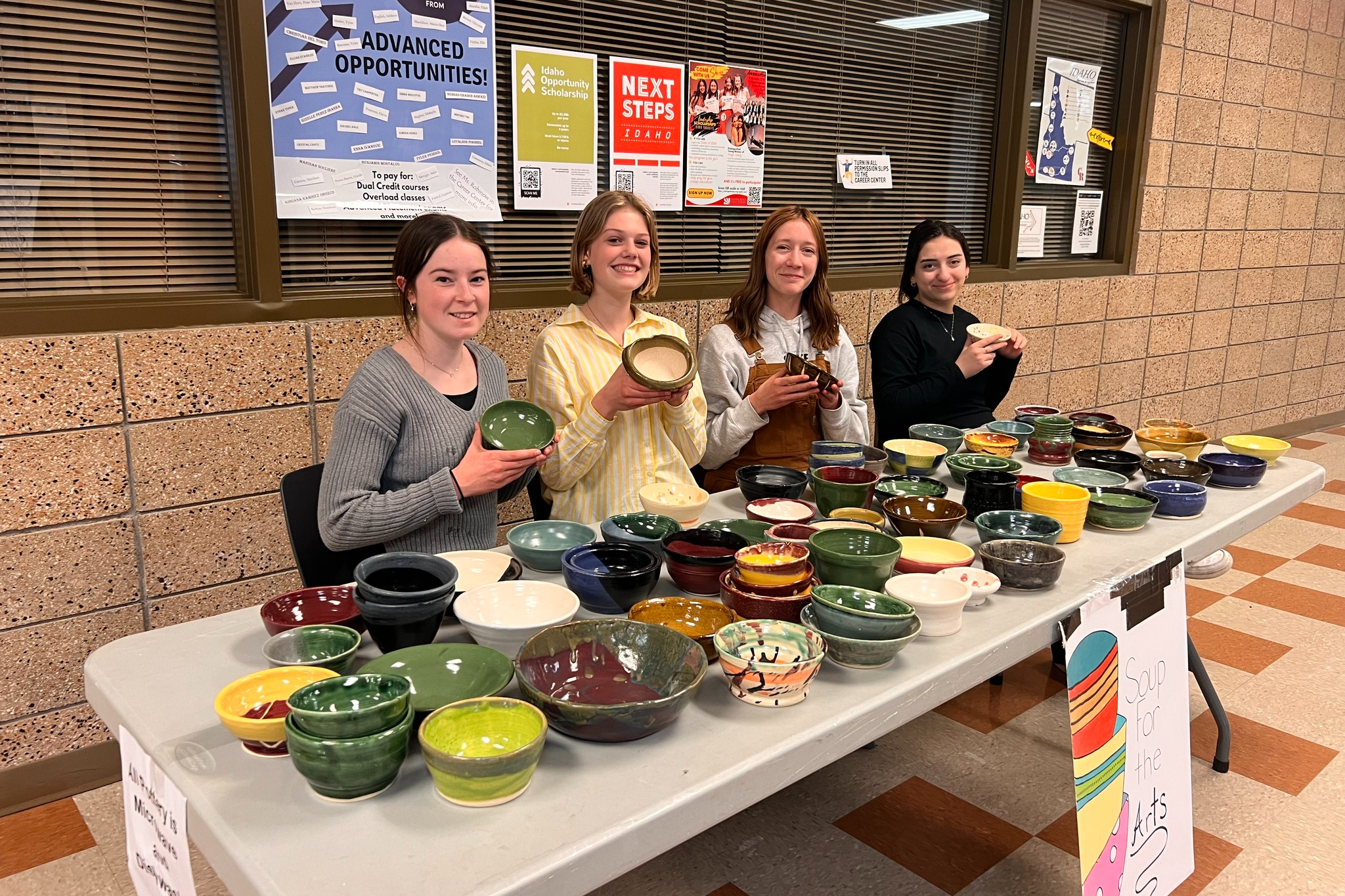 Pottery students hold bowls that they created