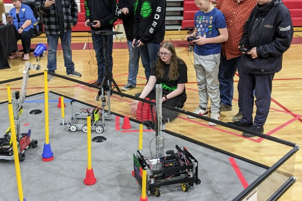 Students move their robots through a competition.