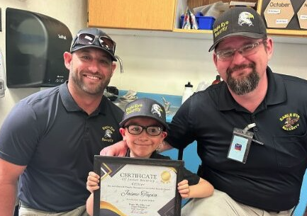 two adults and a kid showing a diploma