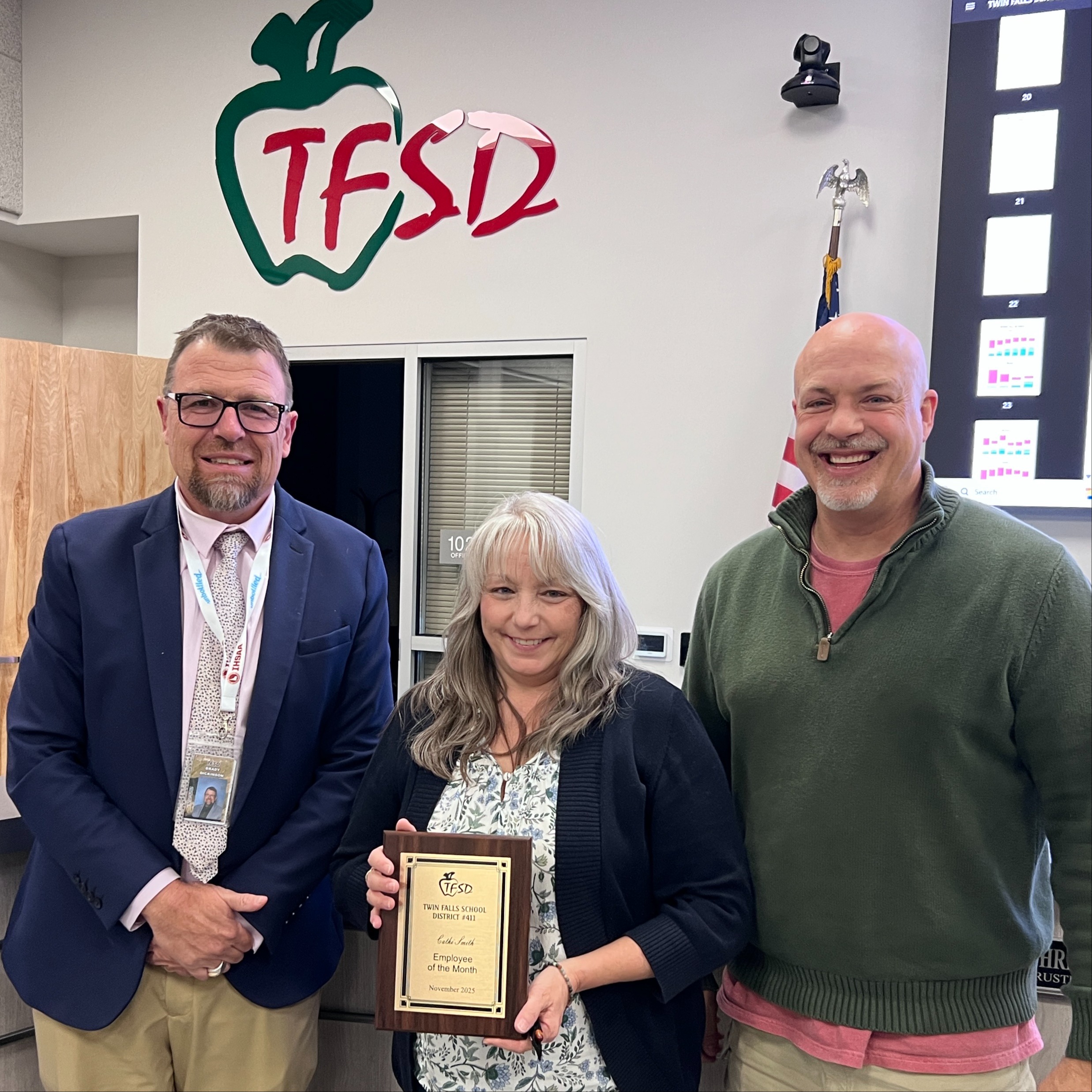 Cathi Smith  receives a plaque from Dr. Dickinson and a School Board  trustee.