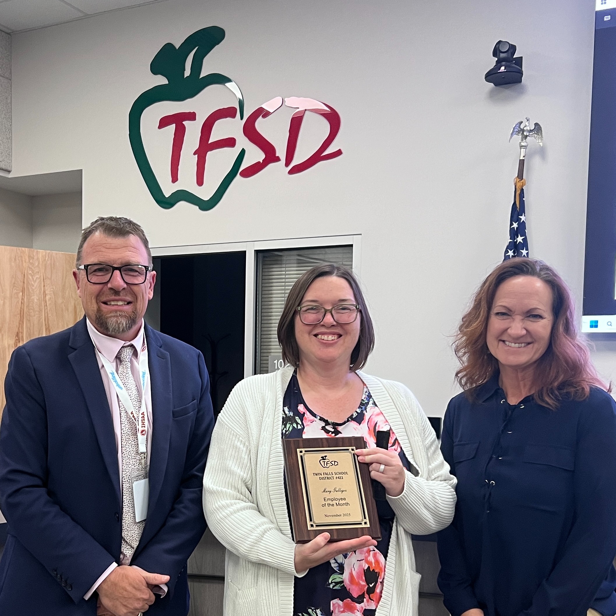 Mary Gallegos receives a plaque from Dr. Dickinson and a School Board  trustee.
