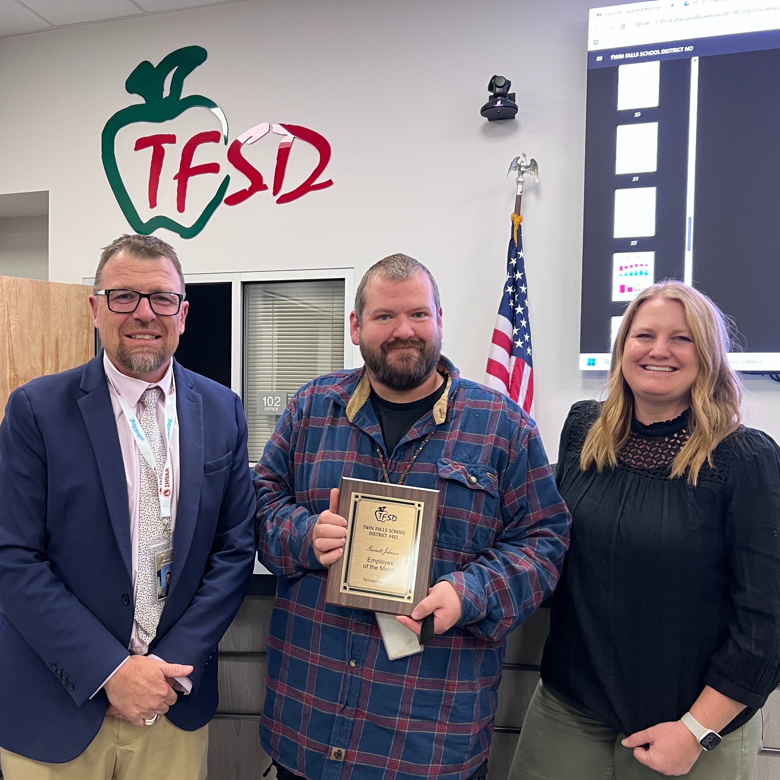 Garrett Johnson  receives a plaque from Dr. Dickinson and a School Board  trustee.