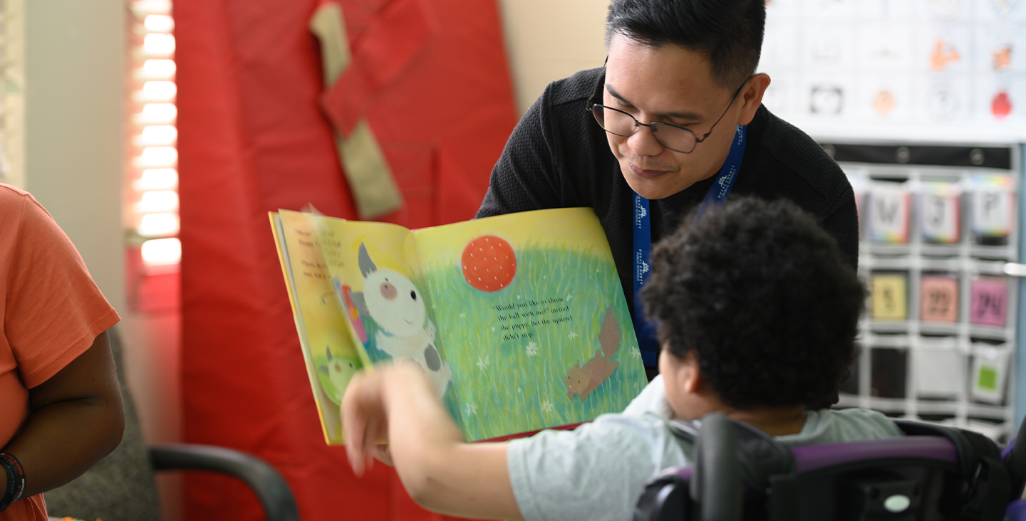 student reading book to class