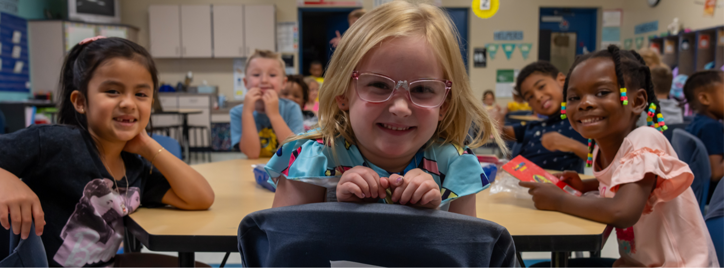 students posing for picture at desks