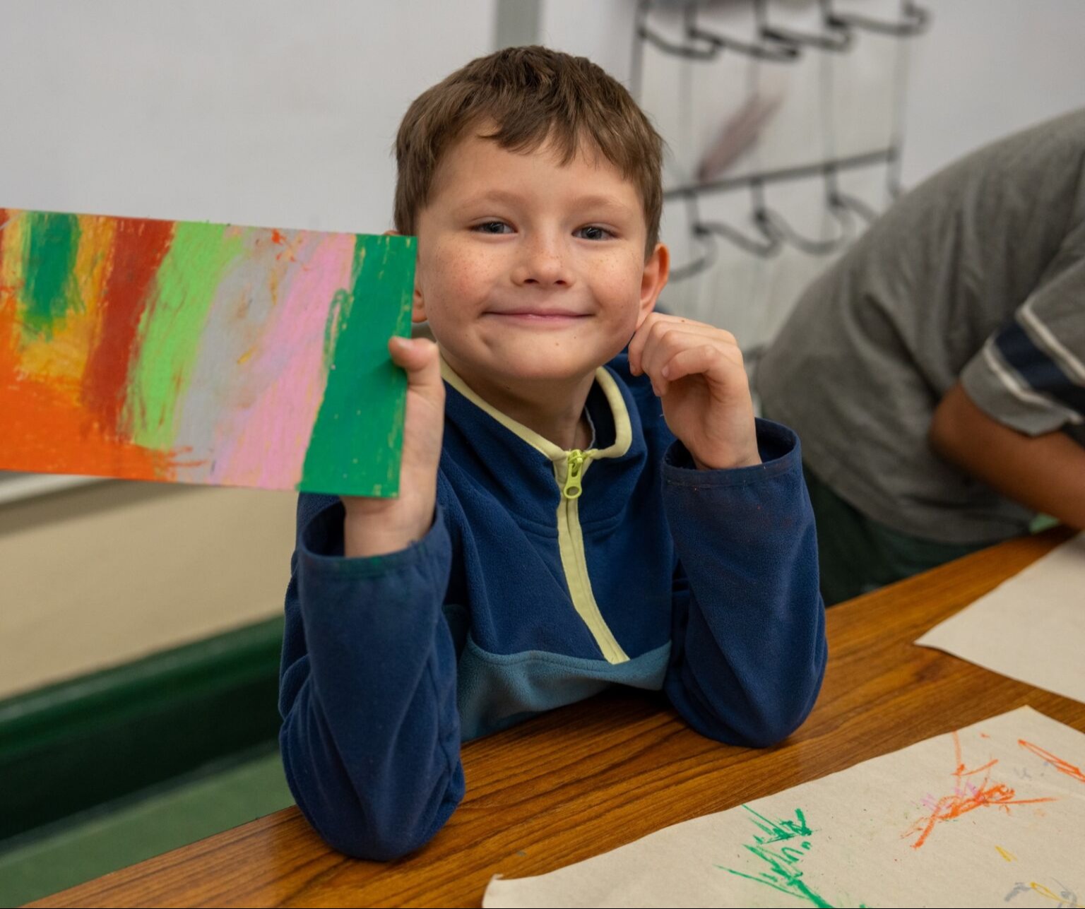 Student holding up his art work