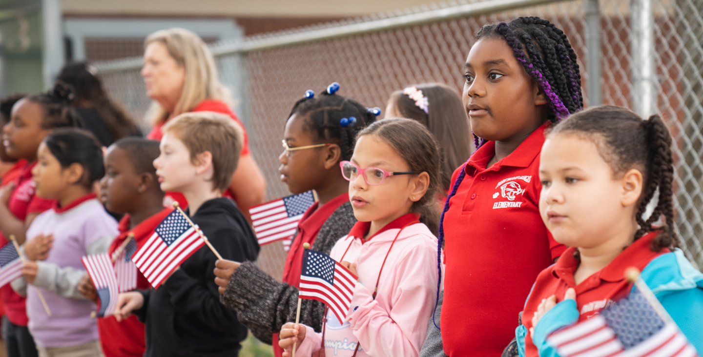 group of students singing and waving flags