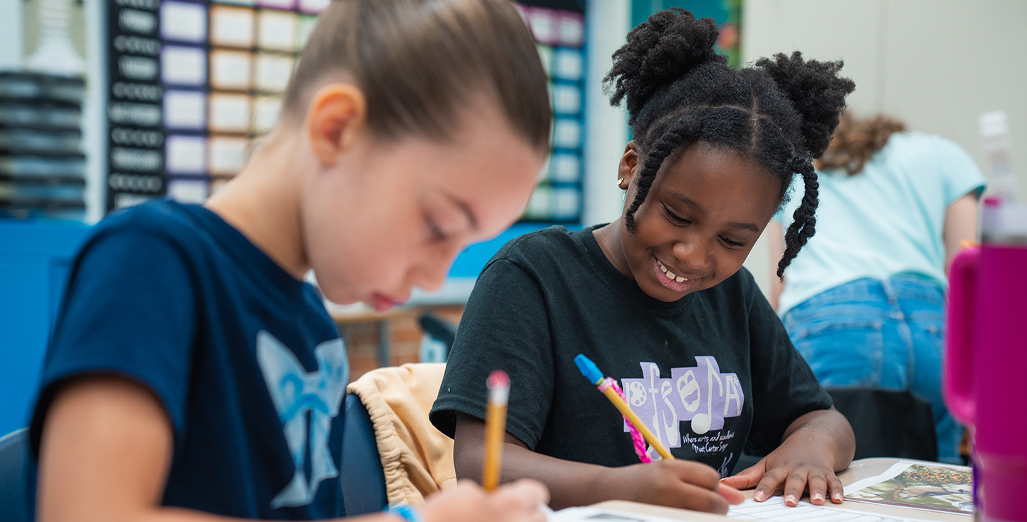 two students working together at their desk