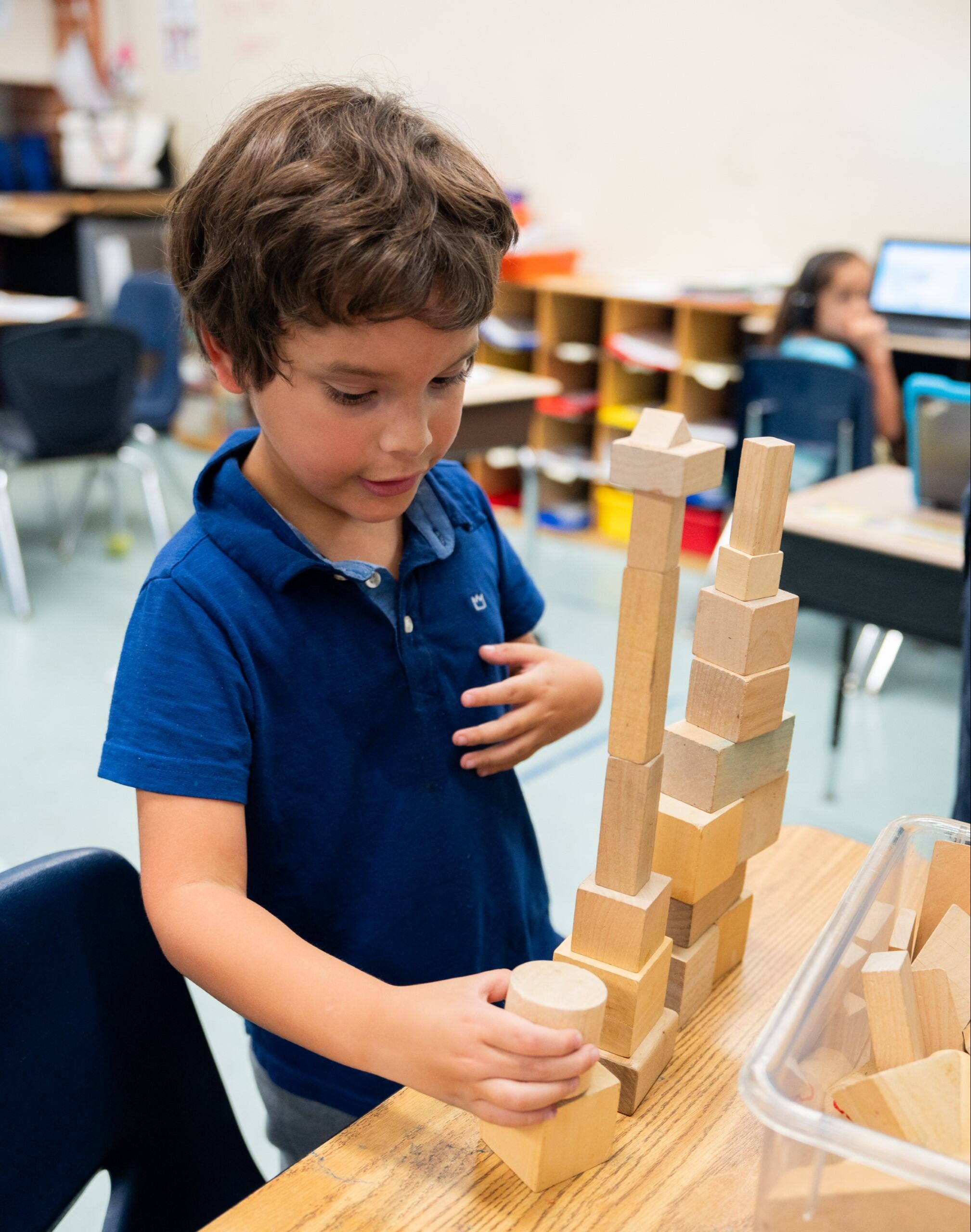 A student stacking blocks to make a tour