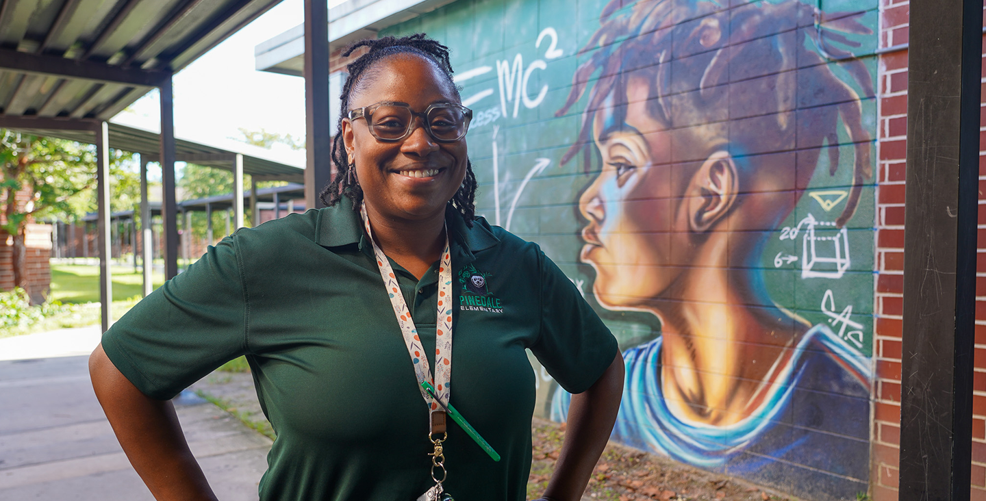 teacher outside by mural