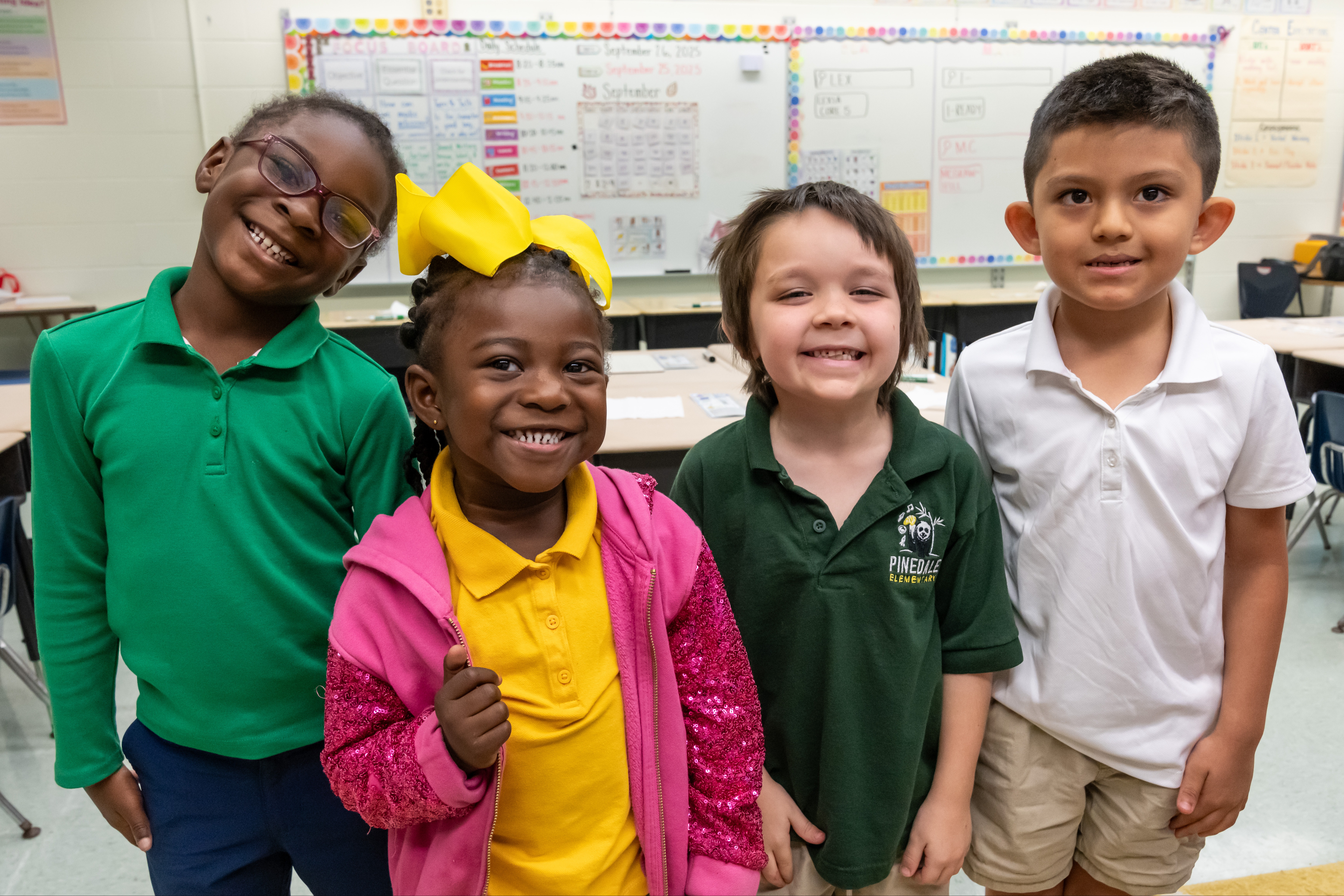 Four students smiling in class