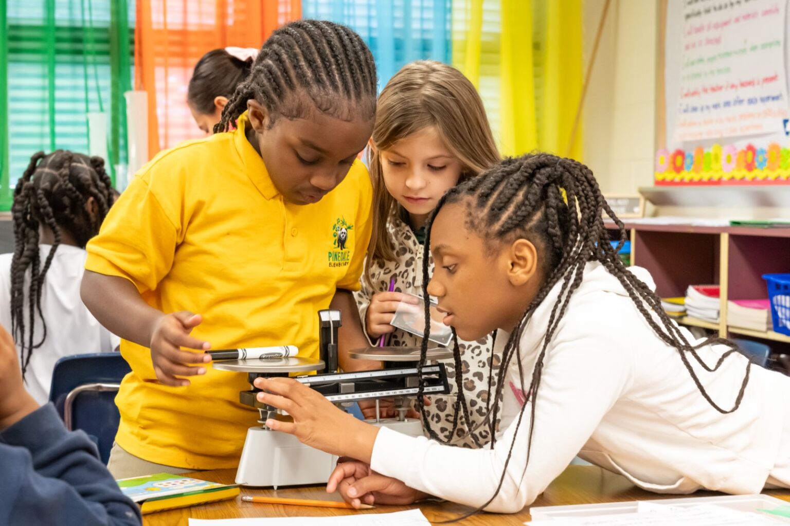 Three girls measuring a market