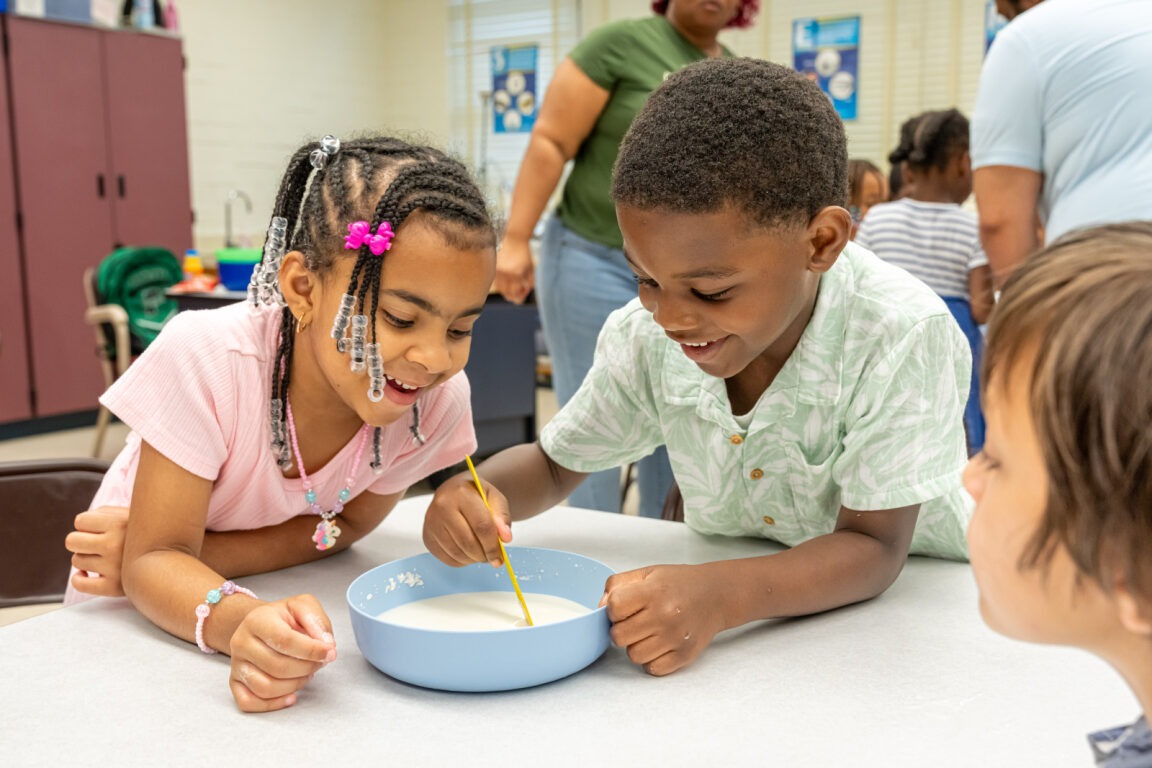 Two students mixing a substance in STEM class