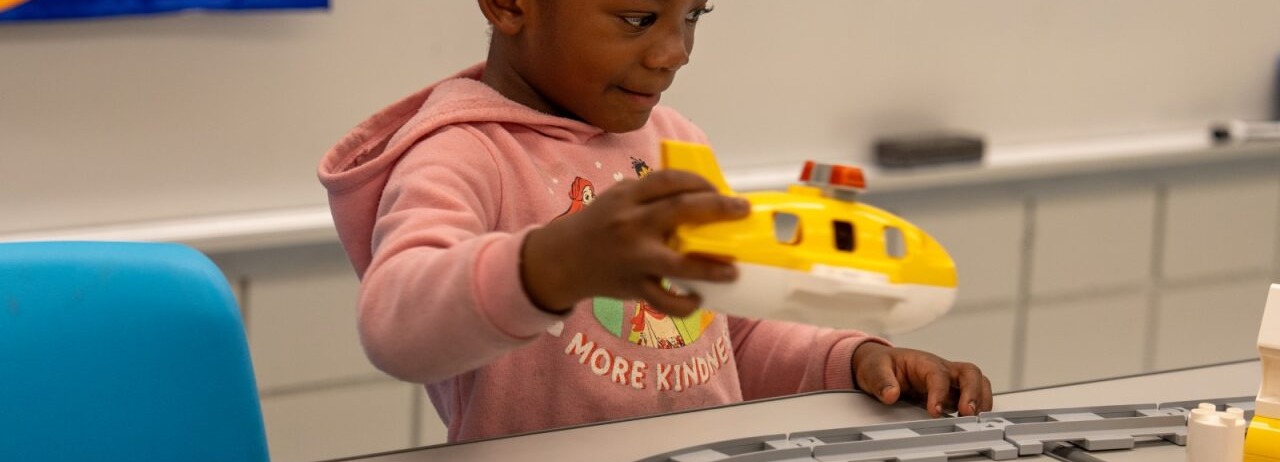 Student playing with an airplane