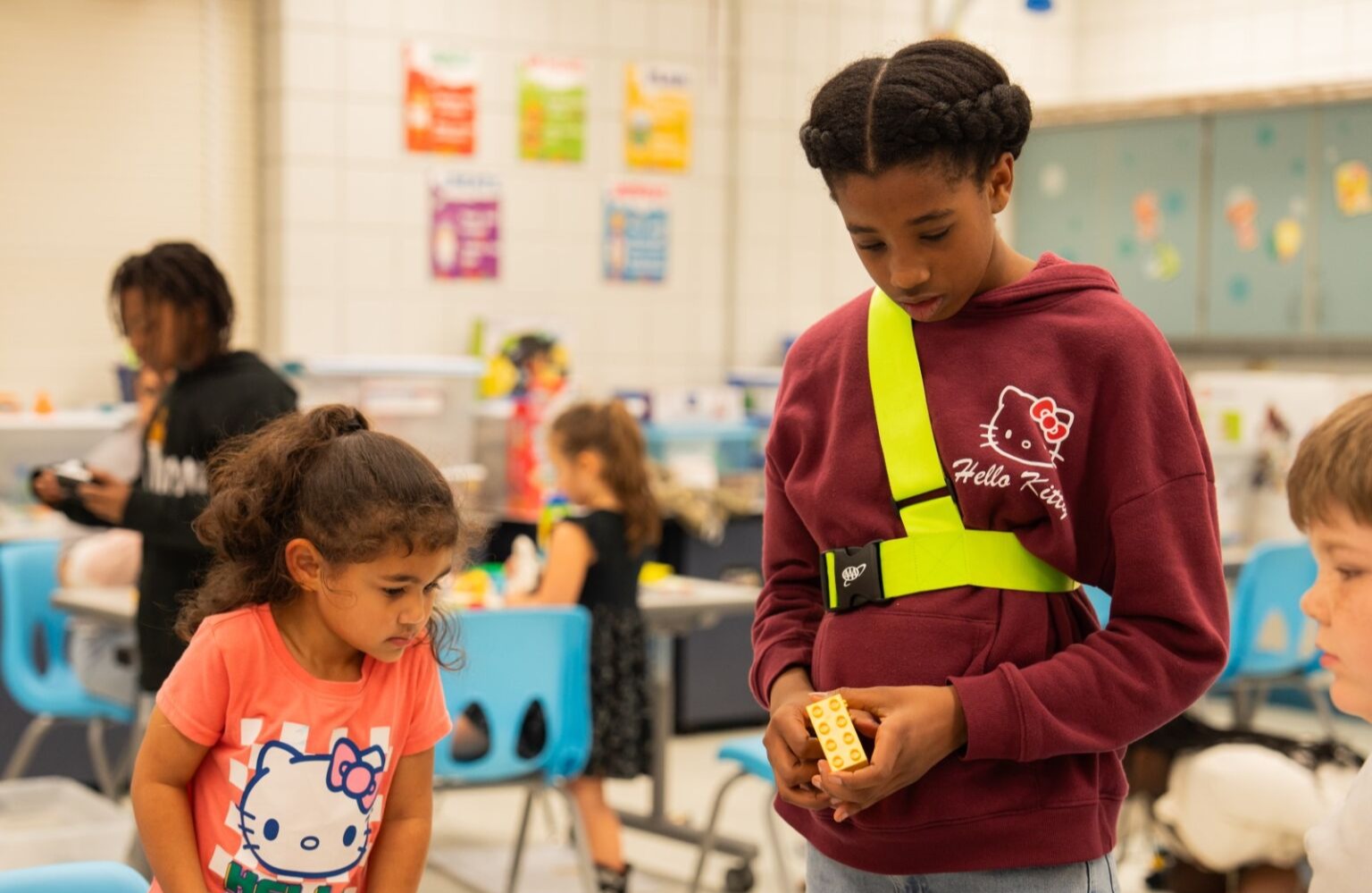 A 5th grader helping a kindergartener with legos