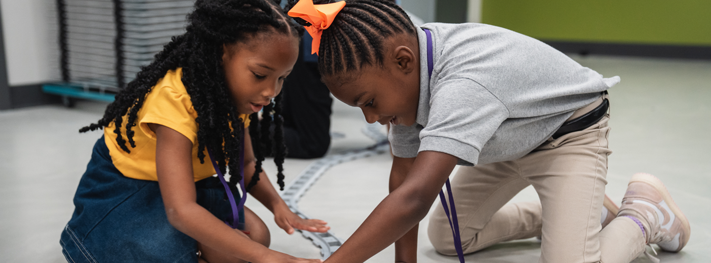 students working together to build a train track