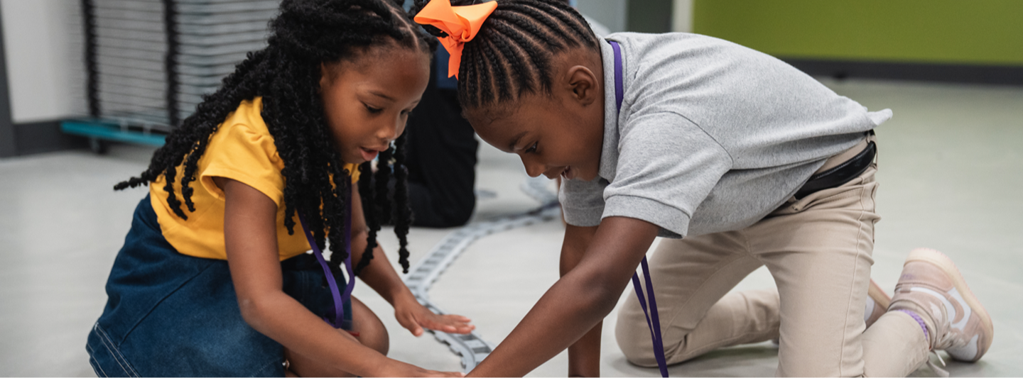 2 students playing with train