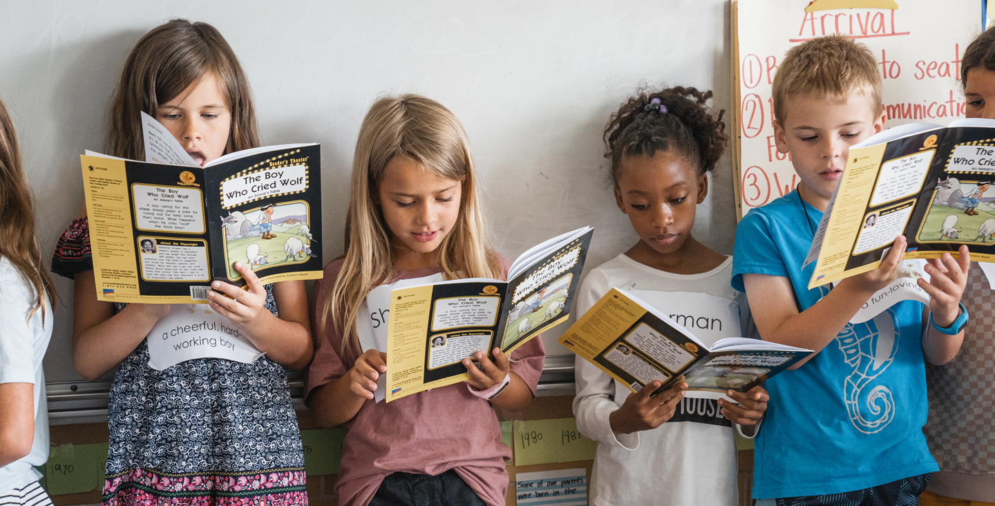 Kids all reading a book together in class