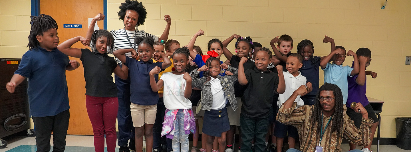 class of students flexing for the camera