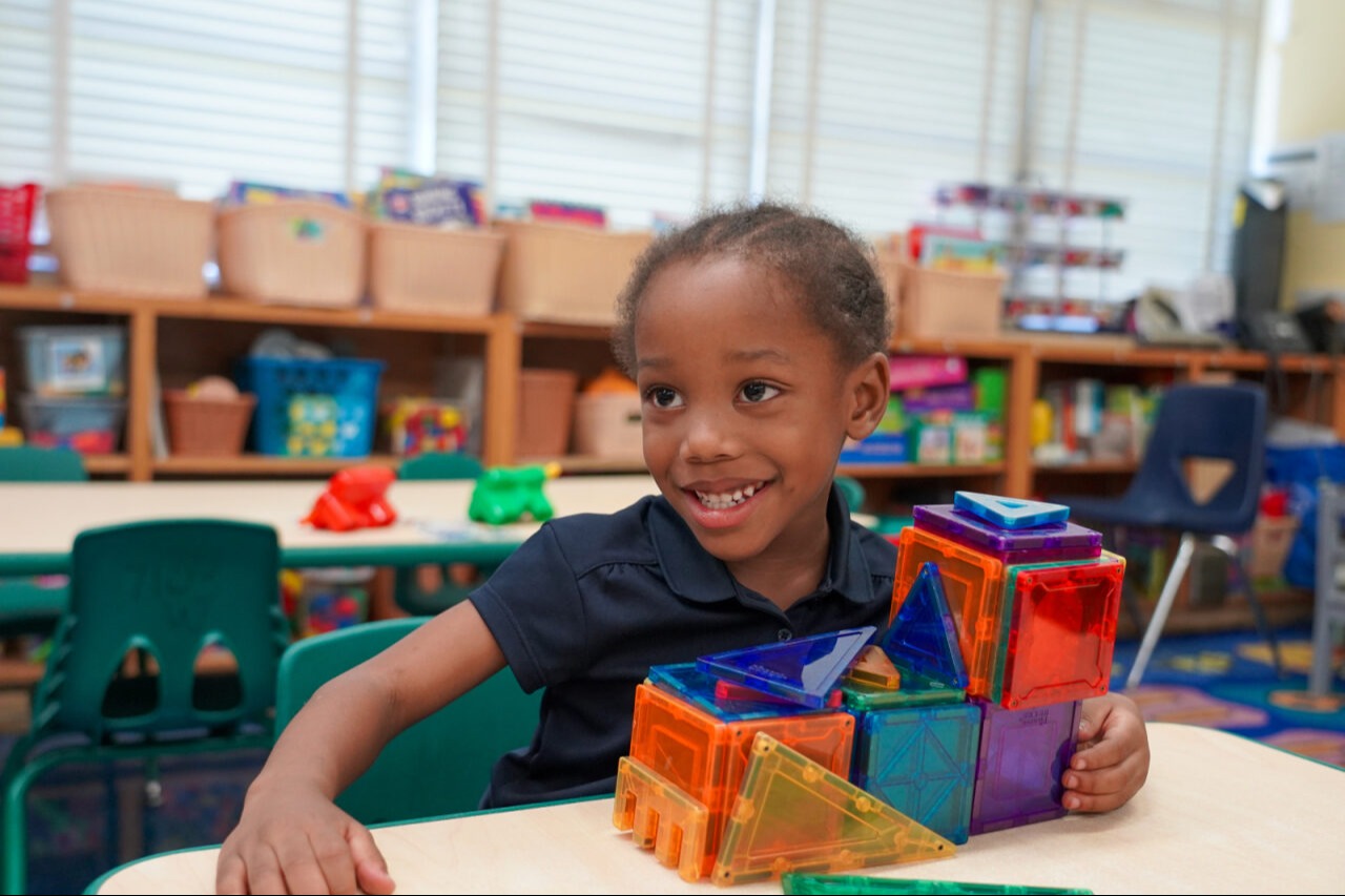 Student with a building made out of blocks