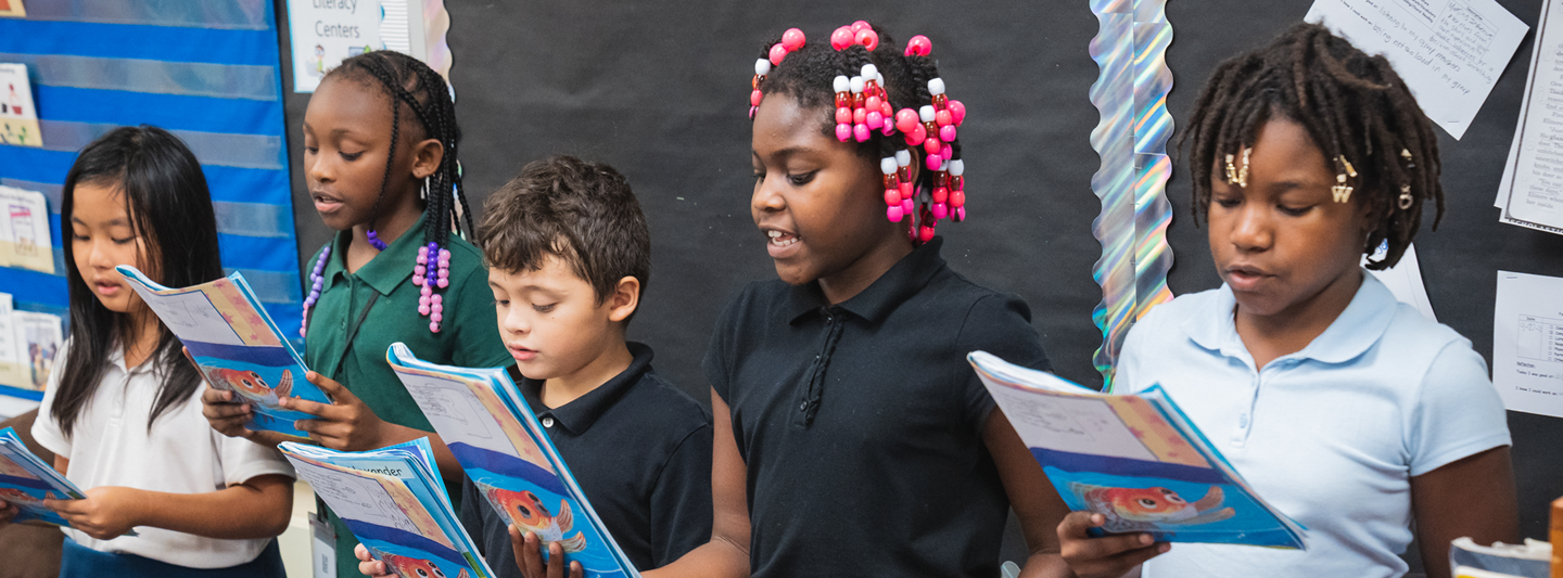 group of students reading out loud from their workbooks