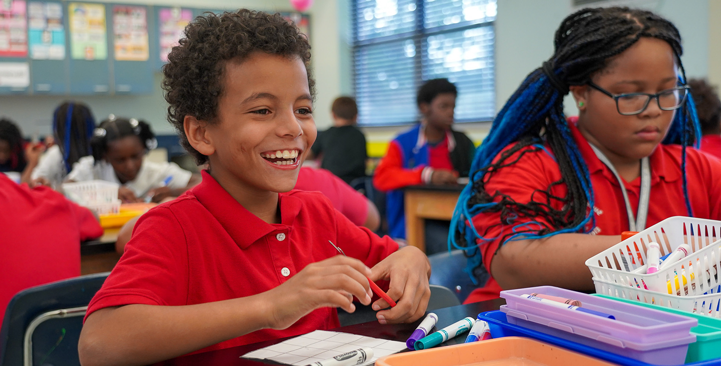 smiling student at desk doing classwork