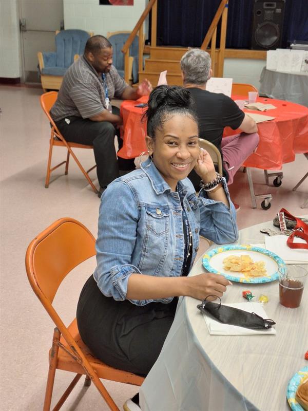 Woman sitting at a dining table with a plate of food.