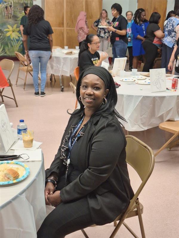 Woman sitting at a table at an event.