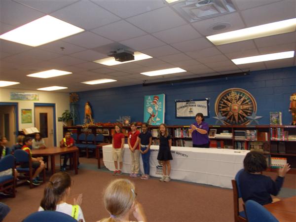 A group of students participating in a school event with an adult, possibly a teacher or school administrator.