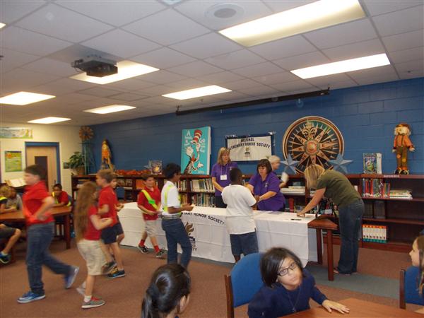 A busy school library filled with students and staff.