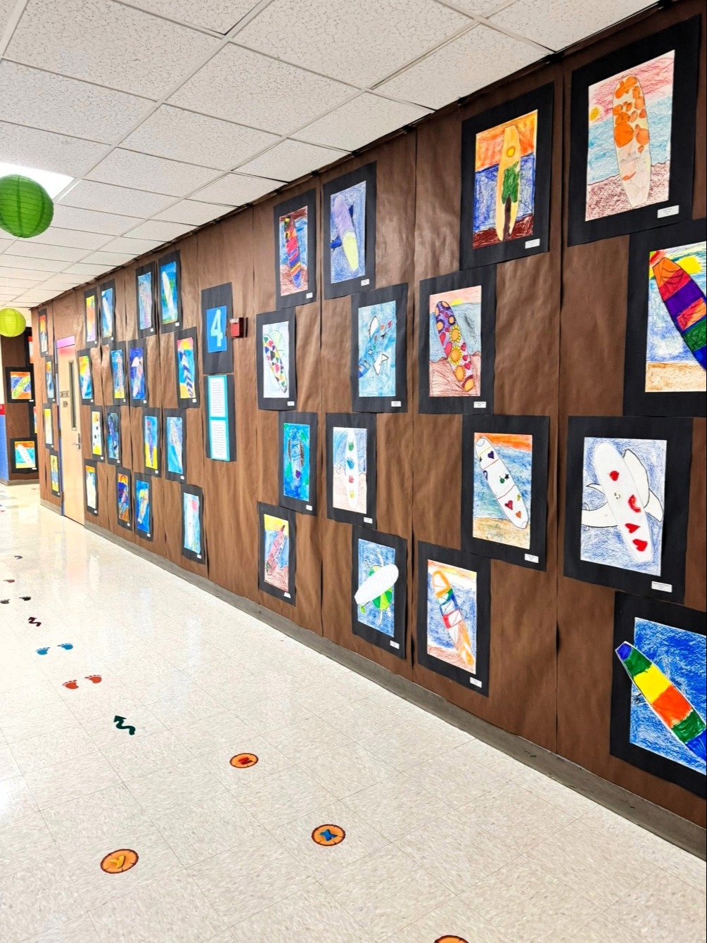 A hallway with wooden walls displaying a series of framed artwork. Artwork depicts various themes.