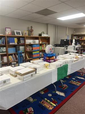 A room filled with books and a table laden with assorted boxes and treats.