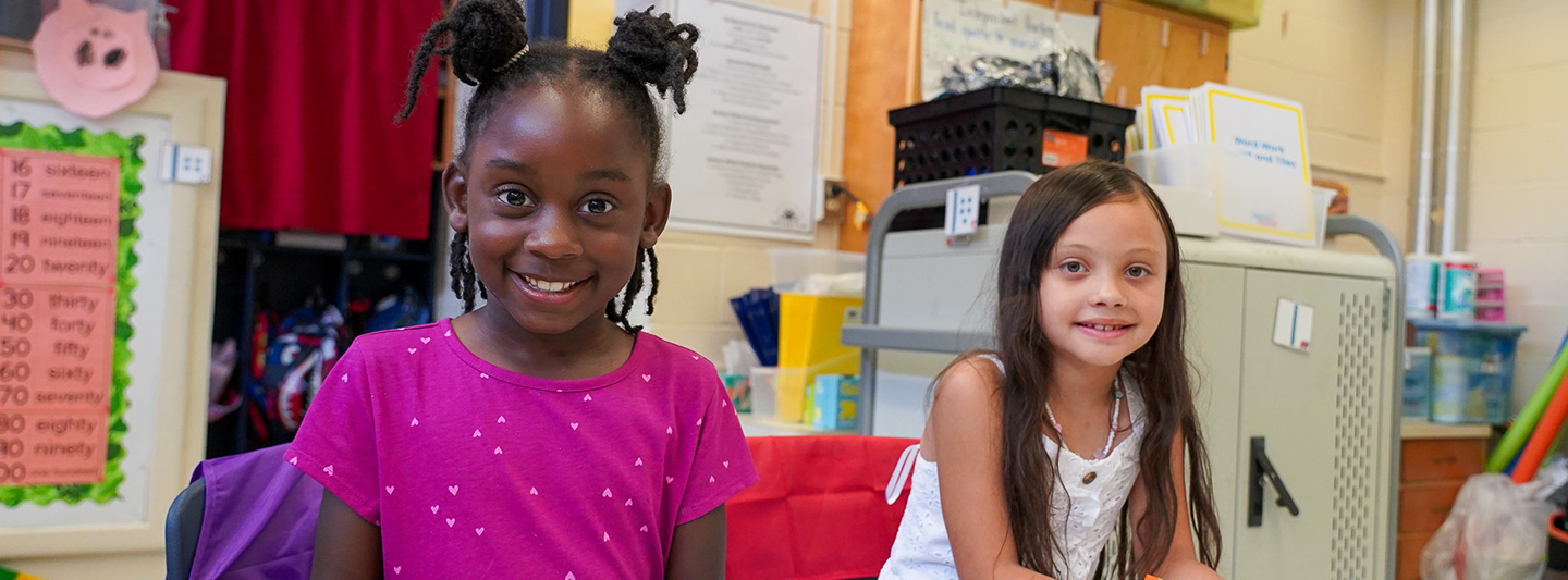 two students smiling in a classroom