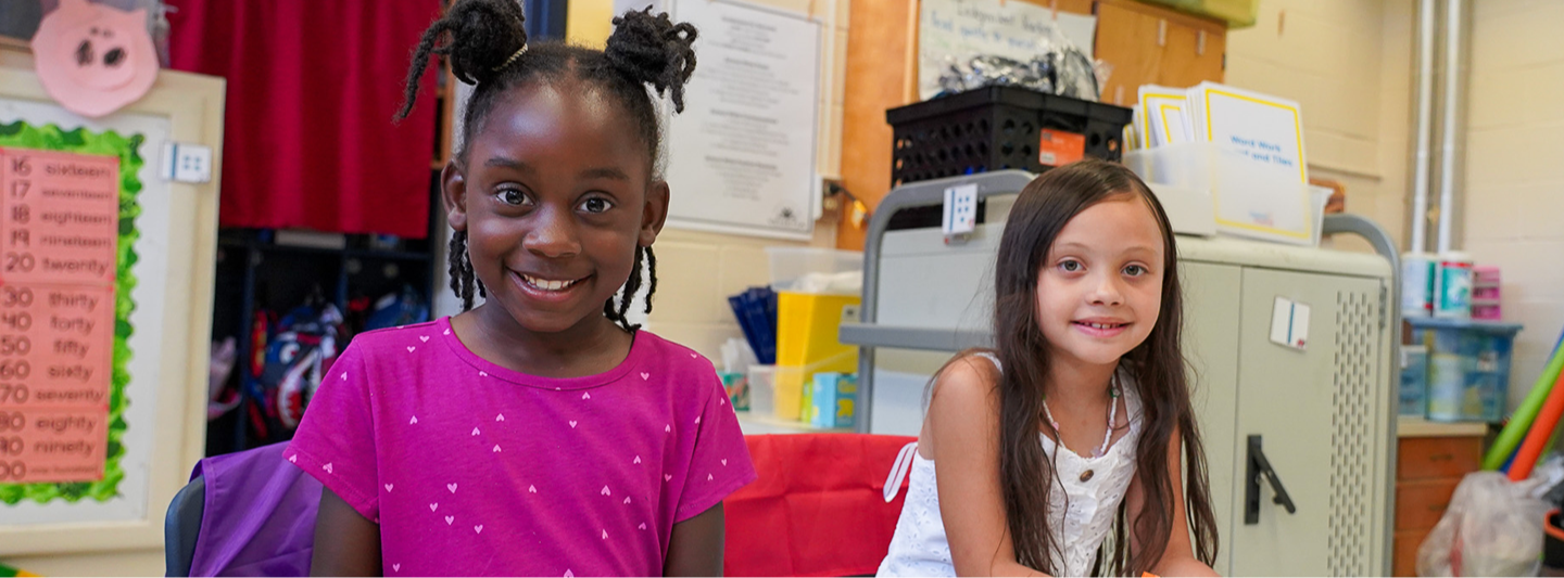 2 students smiling in class