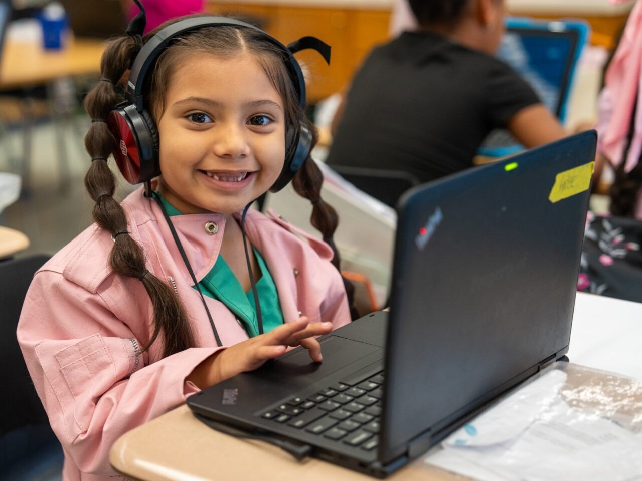 Student on a laptop smiling at the camera