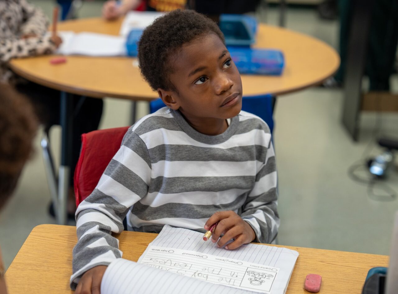 student looking up and thinking while working on an assignment