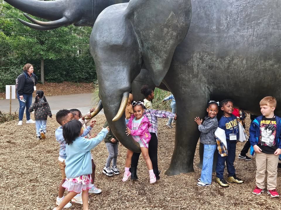 children playing at zoo elephant statue