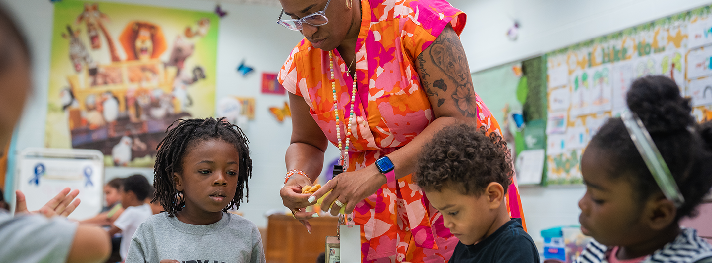 teacher helping students with a craft