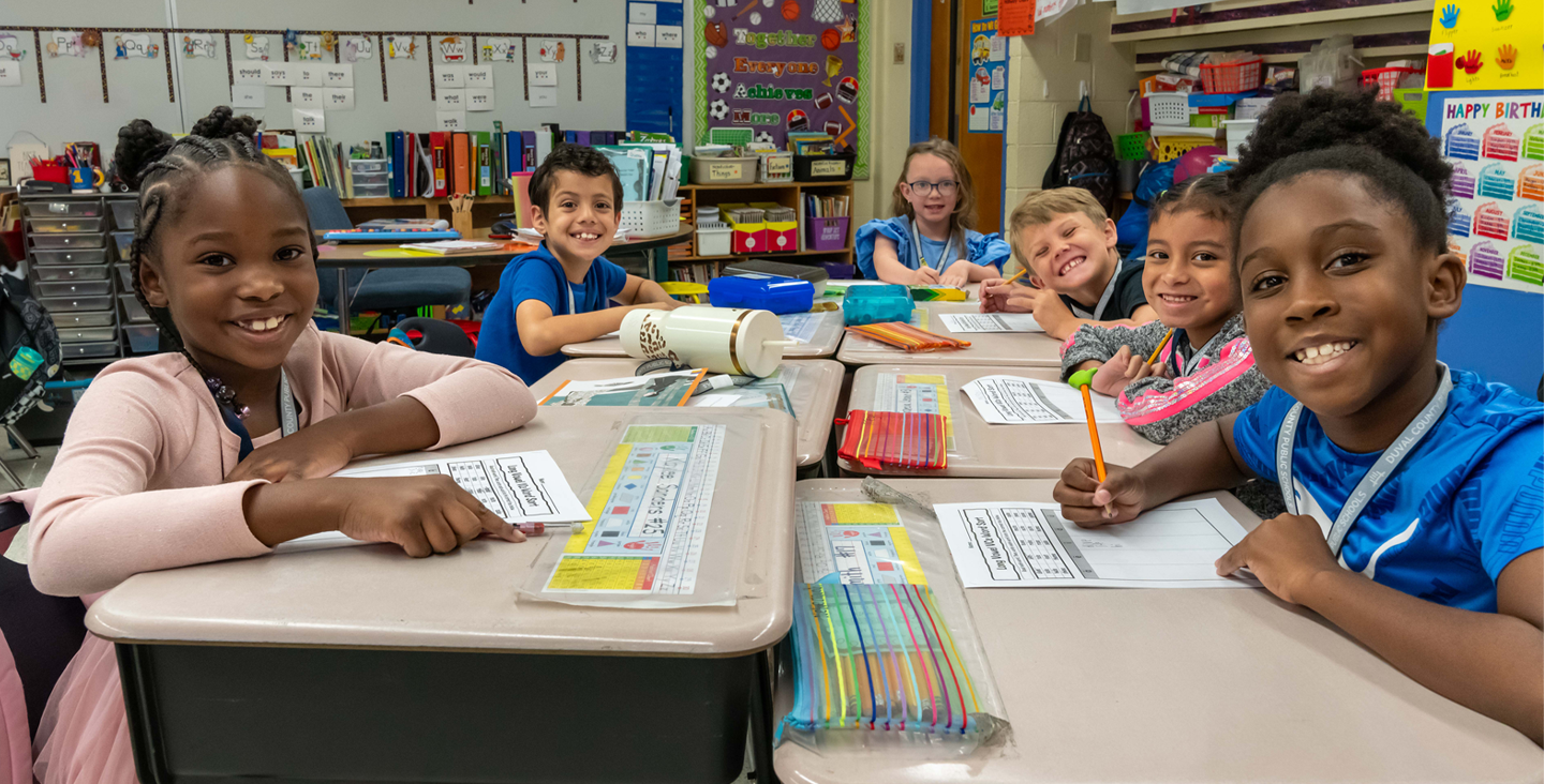 smiling students working at their desks