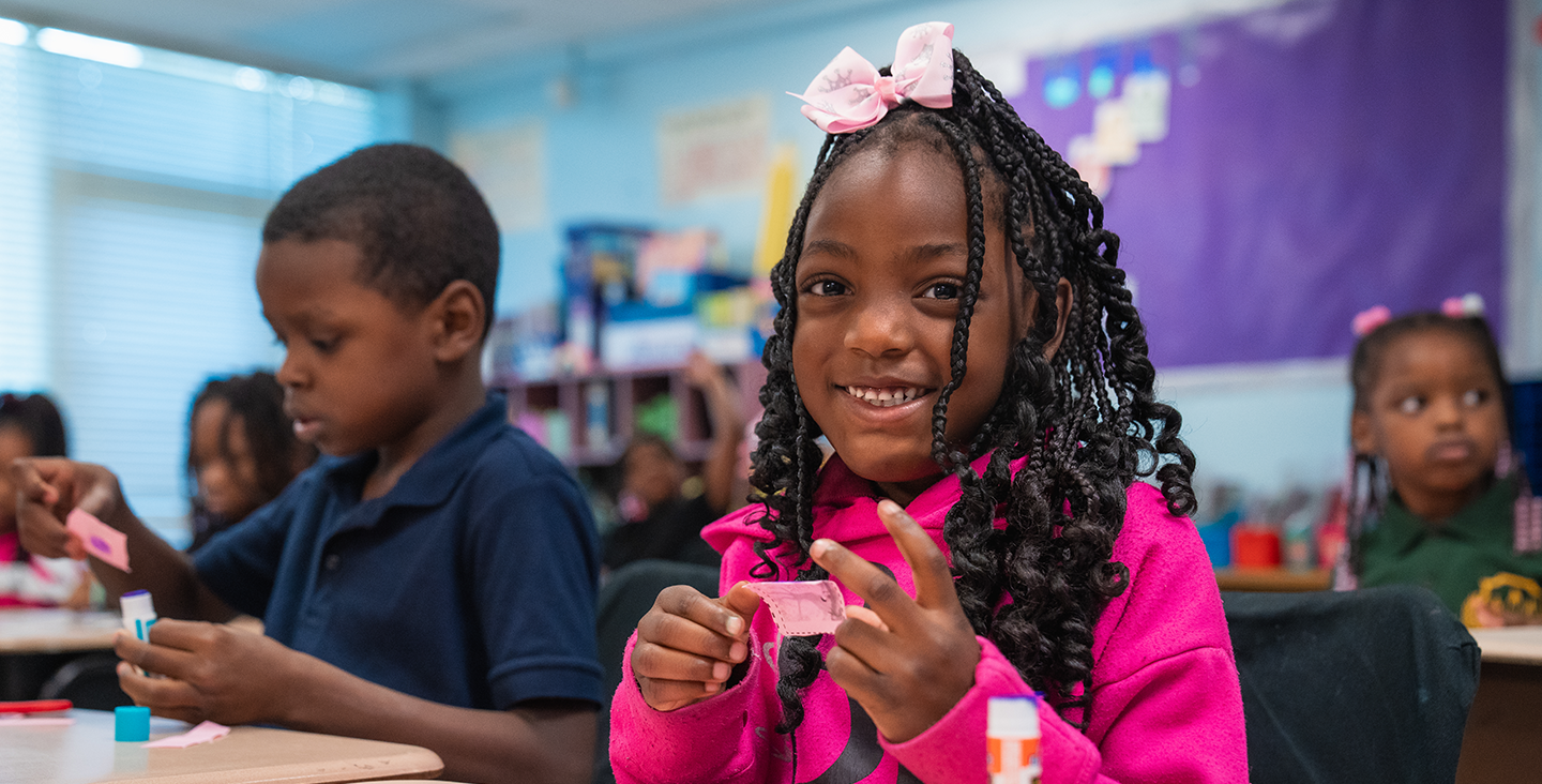 student smiling while working on a craft