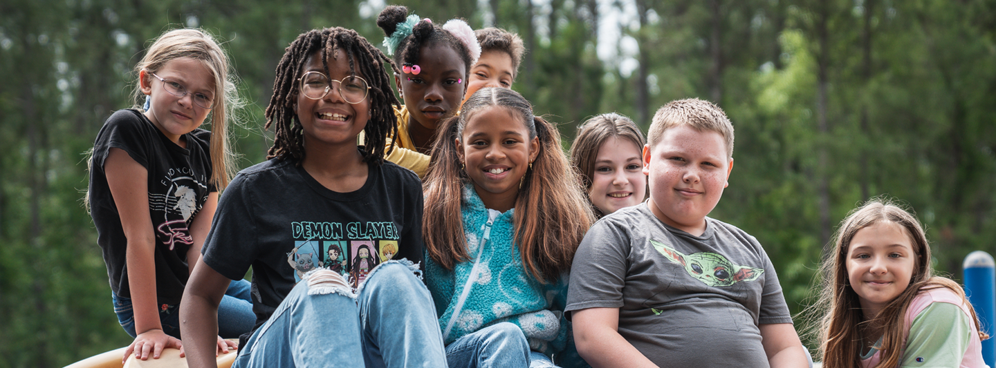 group of students sitting together on playground equipment