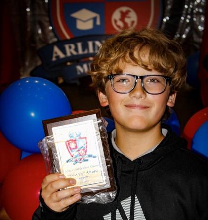 student smiling holding an award