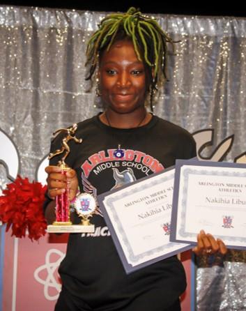 student smiling holding an award