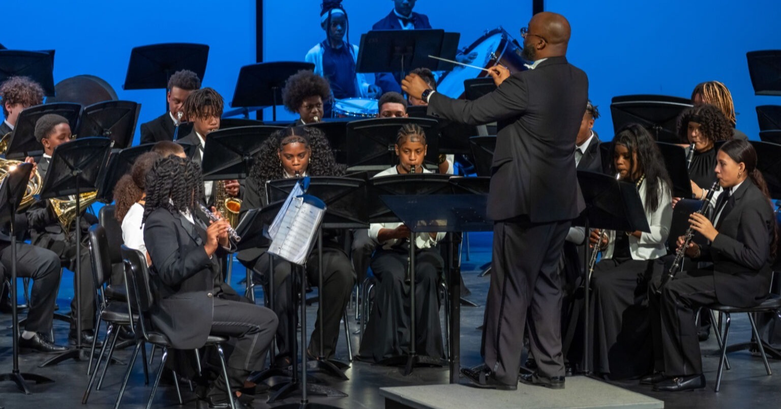 Students playing in a band with conductor